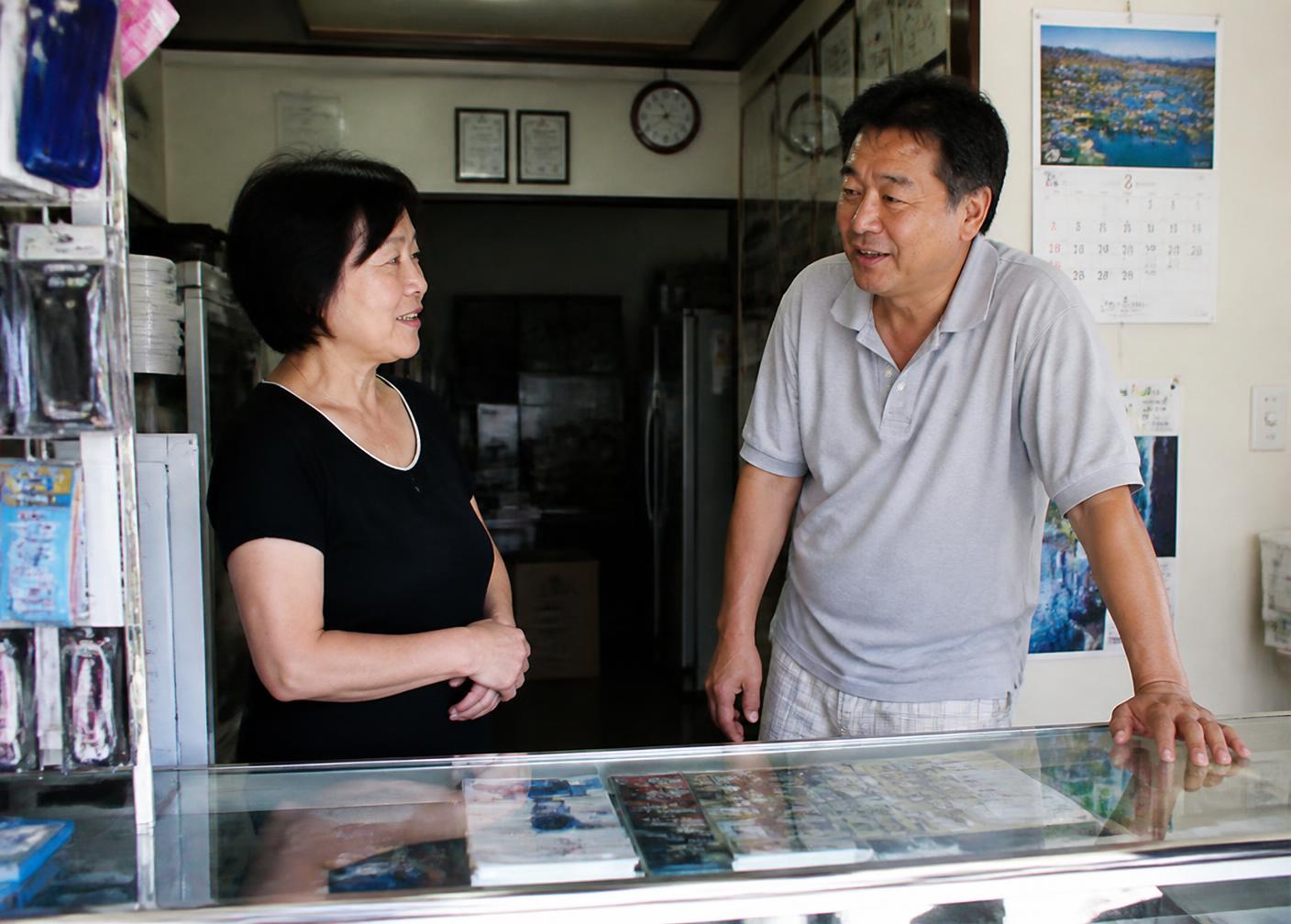 A local business owner talking warmly with staff and customers inside a shop